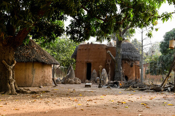 Traditional beninese tata somba house with firewood and a jump hanging from a tree.