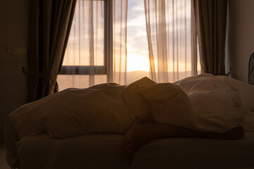 Foot sleeping in the morning at dawn, the girl hangs down the bed. Spy photo. Deep sleep.