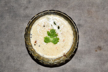 south indian cuisine - White coconut chutney served in a glass bowl.