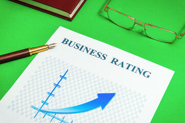 The business rating chart on the green office desk with notebook and stylish pen, business idea