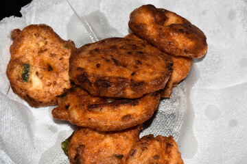 south indian cuisine- very oily Medu vadai or Vada kept on kitchen tissue. Very popular south Indian snack. Selective focus applied.