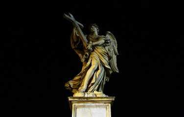 Angel's bridge in Rome. Marble statue of the Angel with the Cross flying. Night, black background