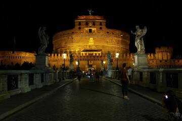 Plakat Sant'Angelo castel in Rome at night, seen from the Ponte dell'Angelo. Streetlights on black sky.