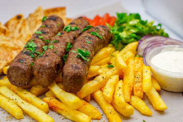 Chargrilled Greek / Arabic Lamb / Pork Skewers Served with Fries / Chips Salad Tzatziki Sauce Tomatoes Onions Lettuce