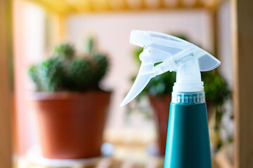 Blue plant sprayer with unfocused background plants.