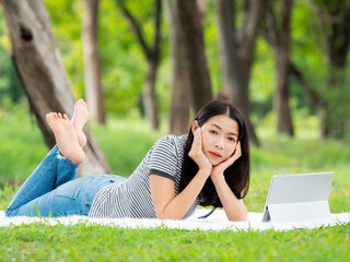 A beautiful Asian woman is relaxing in the garden, Read and search for learning information from the internet