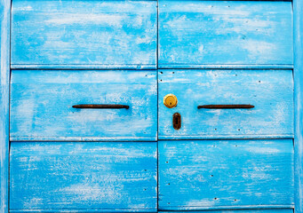 Detail of blue wooden door with ancient and new door lock - Old traditional blue wooden door and ancient iron handles - Typical design of seaside village - Door of paradise and spirituality concept