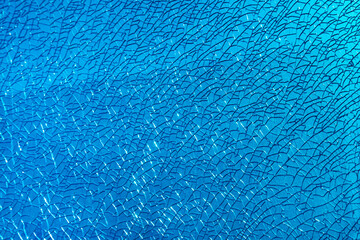 Background of cracked glass in the contoured rays of the blue sun beautiful rainbow pattern, abstract design concept.