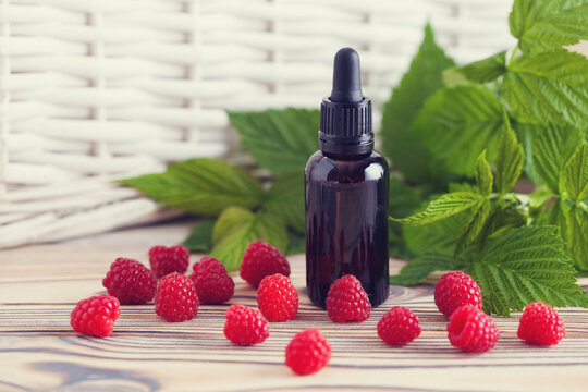 a bottle of raspberry seed oil with fresh fruit