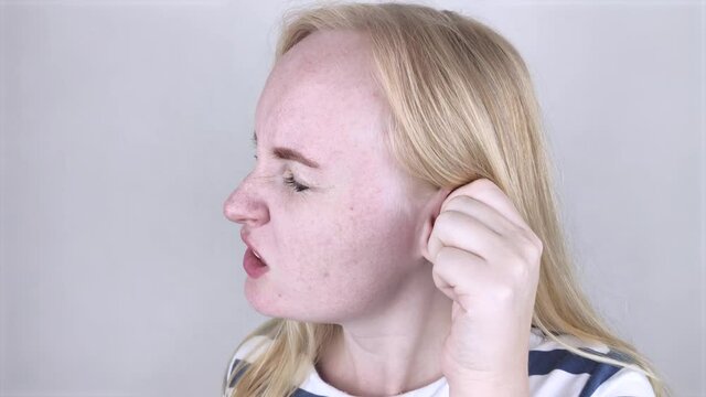 A woman suffers from pain in the ear. The auditory meatus hurts due to otitis media, cerumen plug, ear boil, or trigeminal neuralgia