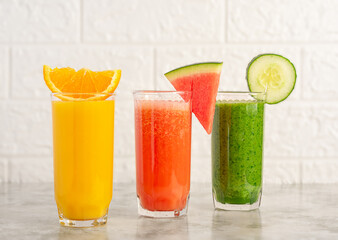 A glass of orange juice, watermelon and spinach smoothie. 