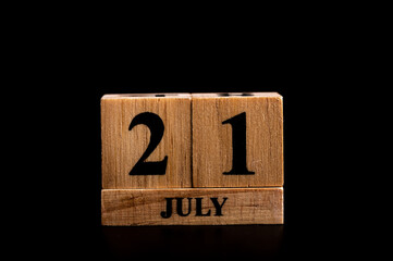 wooden calendar 21 July word on black background with copy space , selective focus at the calendar