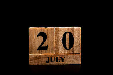 wooden calendar 20 July word on black background with copy space , selective focus at the calendar
