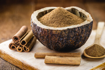 powdered cinnamon and stick, in a rustic wooden bowl, exotic cinnamon from Brazil.