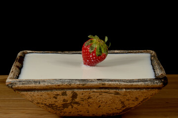 fresas salpicando leche dentro de un cuenco y formando figuras 