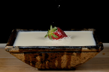 fresas salpicando leche dentro de un cuenco y formando figuras 