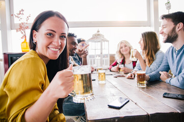 Group of people enjoying drinking a beer in brewery pub 