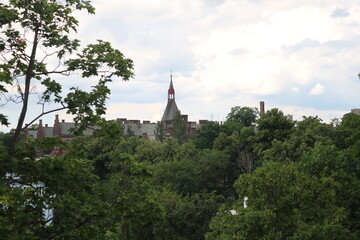 Panorama of the historical center of Prague in green trees on a hot, cloudy, summer day