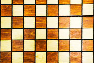 Wooden background of a chessboard. Vintage texture of a chess Board. White and black squares for a popular, favorite game.