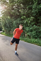 Young man running alone on an empty road
