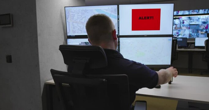 Slow motion footage of security control room operator at work, Security System Operator Looking At Cctv Footage