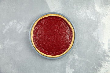 Strawberry tart in baking dish on grey concrete background.