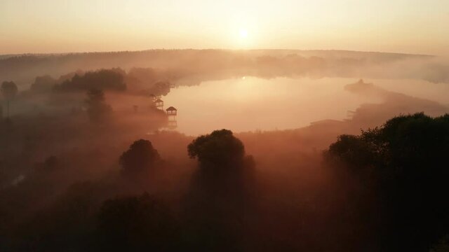Beautiful misty dawn in the spring on the lake. Aerial view