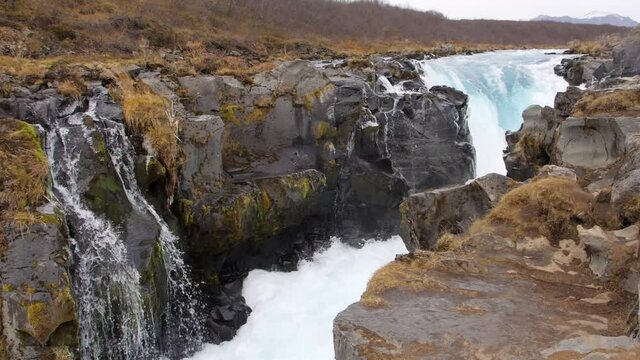 Midfoss waterfall in Iceland, glacier melt water cascades down in slow motion.