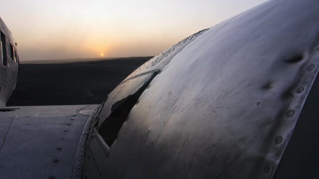 Sólheimasandur DC 3 plane wreck in Iceland close up of wing and engine against setting sun and strong dust winds
