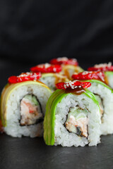 Portion of fresh sushi roll with avocado, strawberry, cheese