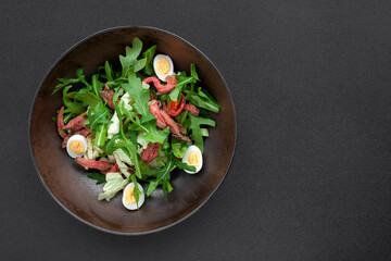 Fresh salad with roast beef meat, cherry tomatoes, arugula, quail egg