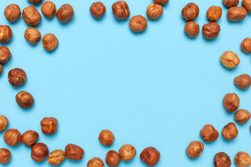 Creative food layout. Hazelnuts on blue background top view copy space. Concept of food, healthy nutrition, nut, healthy fats. Hazelnut Flat lay. Walnut pattern. Organic healthy vegan snack