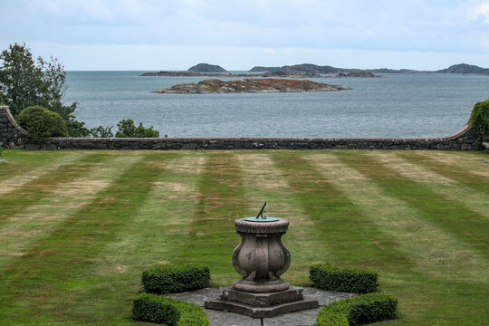 Castle lawn with sun clock and ocean seascape background