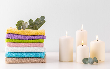 Stack of colorful bath towels and candles