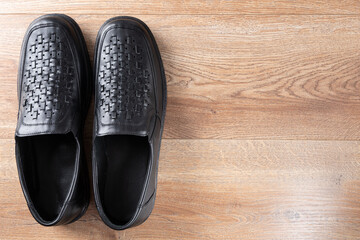 New black men shoes on wooden background. Elastic sided shoes. Side gusset shoes. Lazyman shoes. Top view. Copy space