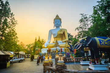 Fototapeta premium Beautiful big buddha image at Wat Phra That Doi Kham. Chiang Mai, Thailand. Wat Phra That Doi Kham (Wat Doi Kham or the Golden temple) is located at the top of a hill to the south west of the city.