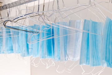 Disposable surgical masks hanging on hangers in a wardrobe closet. Concept of new normal. Concept...