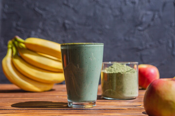 Smoothie with fresh red apple, banana and spirulina powder. Summer vitamin refreshing drink. Healthy detox diet