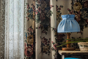 blue lamp and a curtain with flowers in a abandoned house