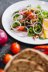 plate of fresh salads and mouth-watering ingredients for cooking, chili peppers, mini-tomatoes, grilled bread, blue onion