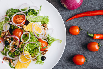 plate of fresh salads and mouth-watering ingredients for cooking, chili peppers, mini-tomatoes, grilled bread, blue onion