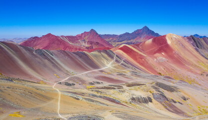 Aerial landscape of The Red Valley at Rainbow Mountain (Vinicunca Valley). Apu Ausangate is behind. Mountain full of colors. Cusco Region, Peru