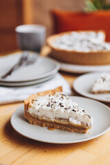 appetizing slice of sand-based dessert with white cream cheese and banana stuffing sprinkled with grated chocolate