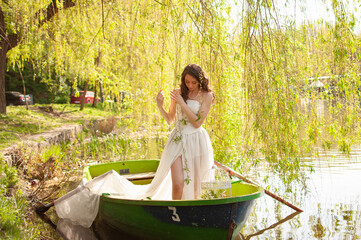 Portrait of young bride in stylish wedding dress on lake