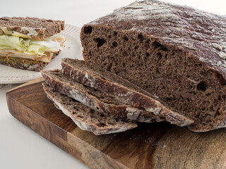 Pumpernickel Bread Sliced with Sandwich in Background Horizontal