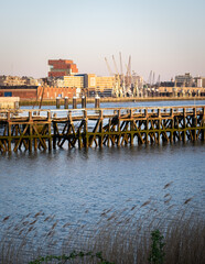 Fototapeta na wymiar Old wooden pier in front of the Northern part of the city of Antwerp, Belgium