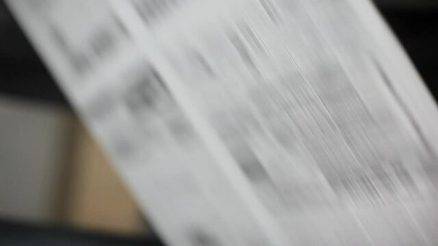 Blurry newspapers moving fast in a printing press factory.