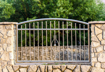 Chrome fence . Chromium Stainless steel fence on stone wall 