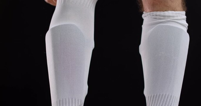 Detail shot of a professional soccer football player adjusting his socks before the match. 4k