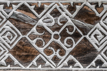 Balinese wood carving. A pattern of curls on the aged wood surface.